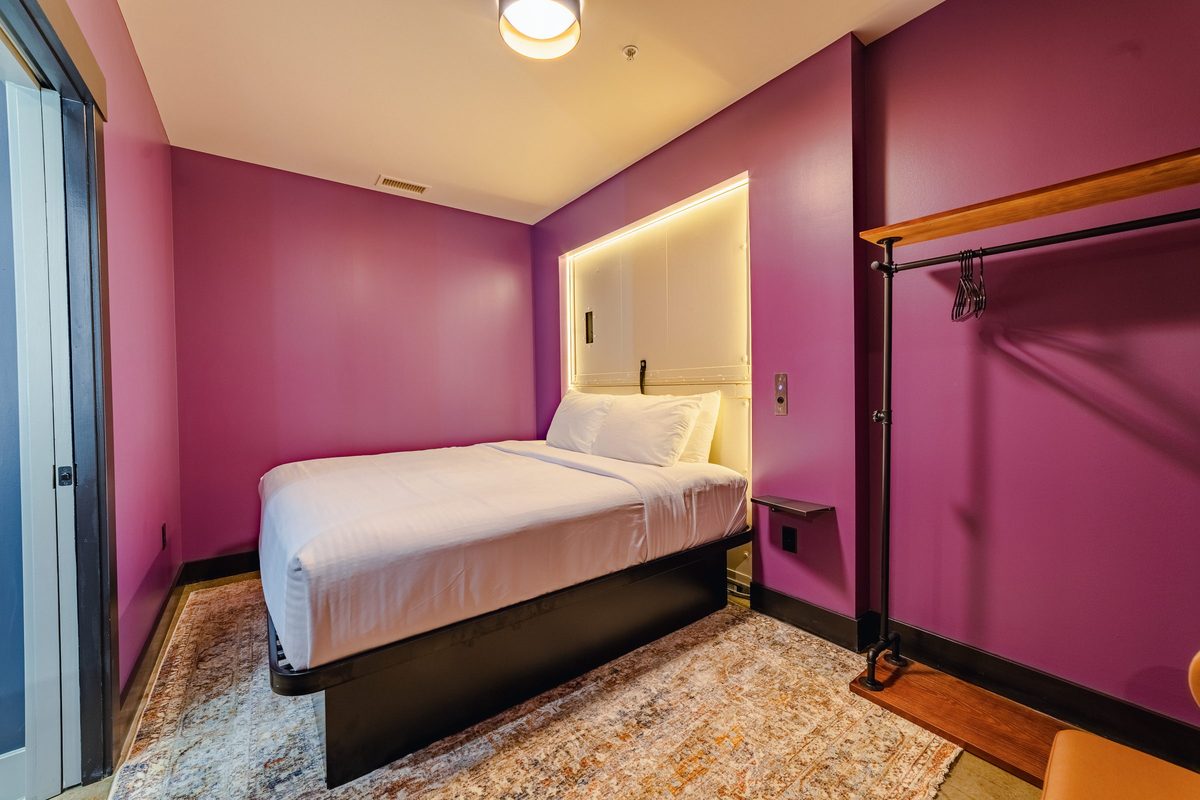 King bedroom with backlit elevator door headboard