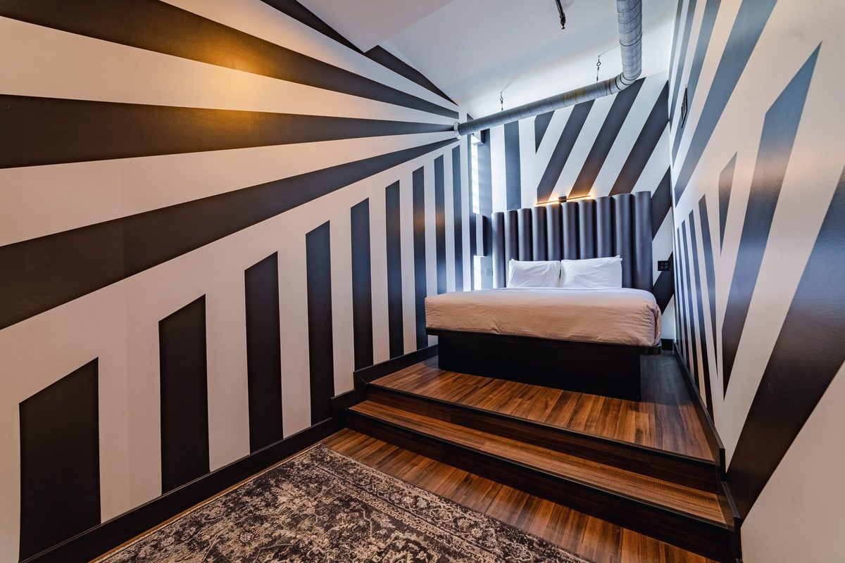 King bedroom with black and white stripe mural
